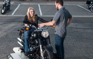 Woman on a motorcycle with male instructor